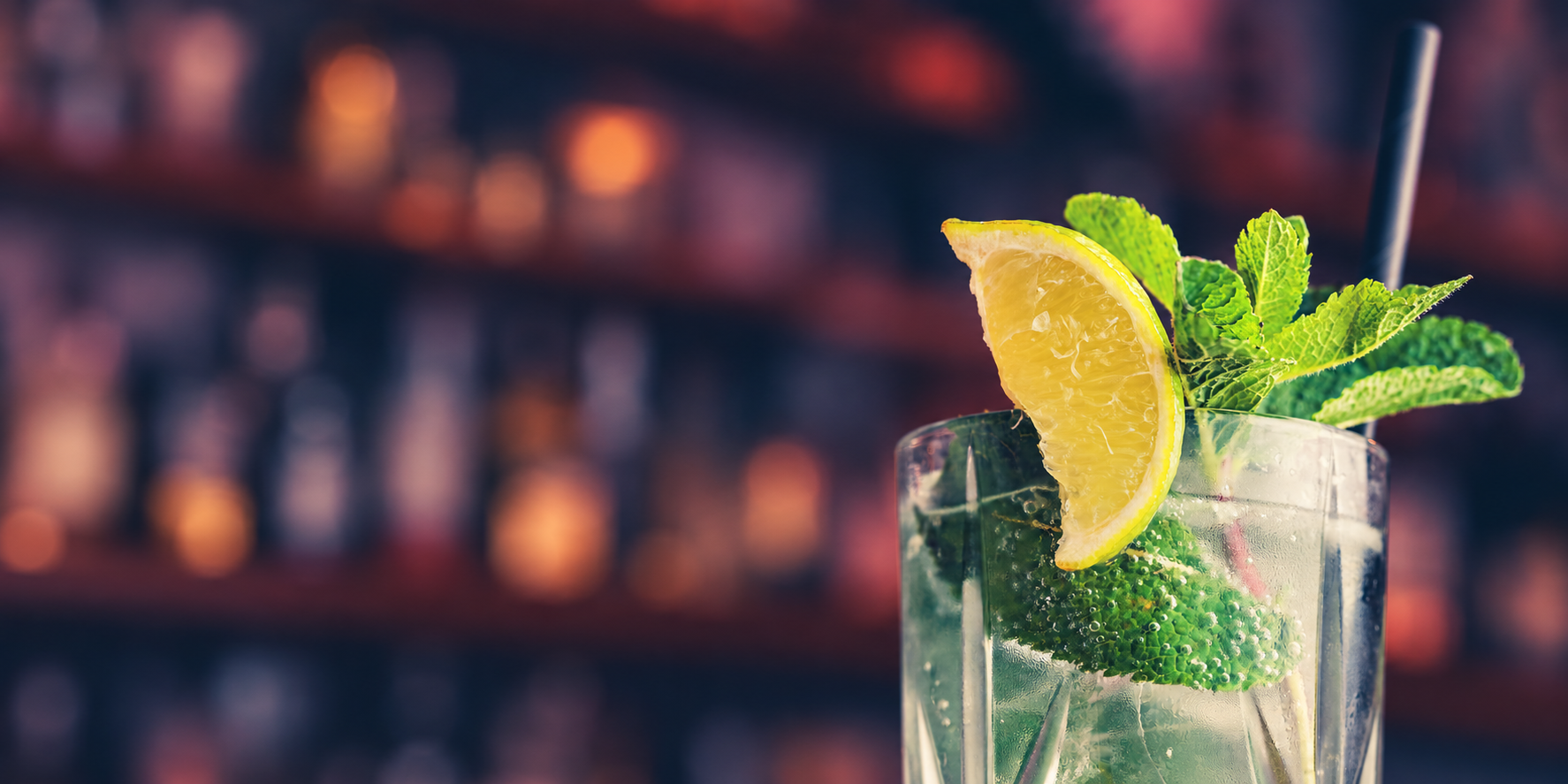 A chilled citrus and mint cocktail against a softly lit bar