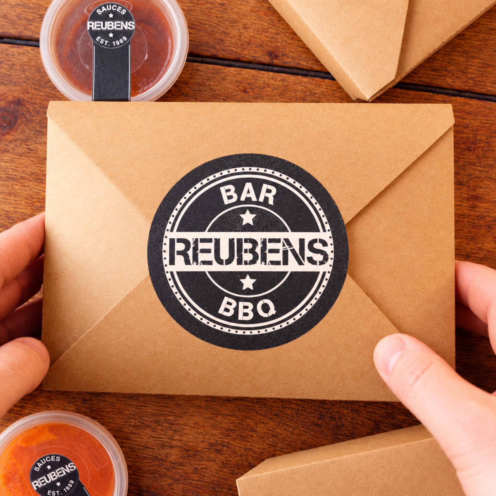 Unpacking a delivered Reubens box beside branded sauce pots