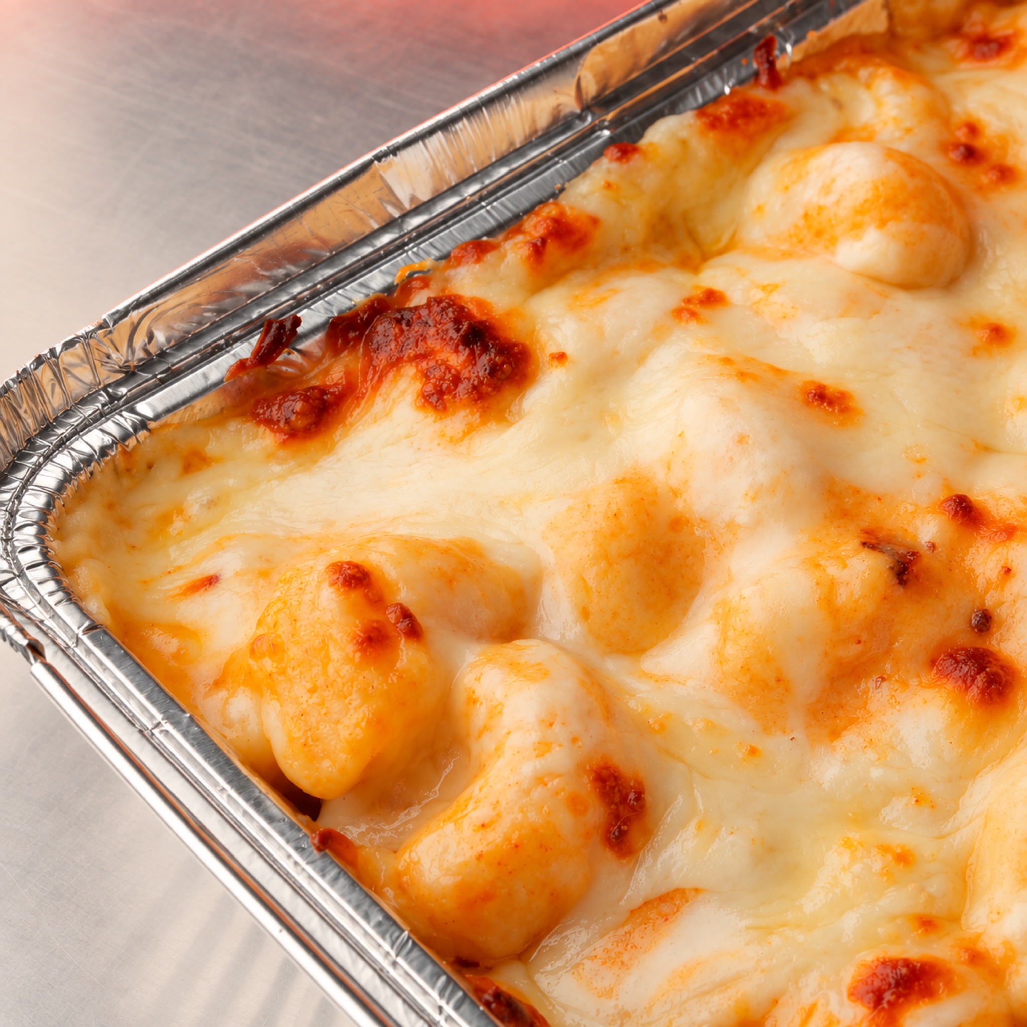 Golden baked mac and cheese in a takeaway tray