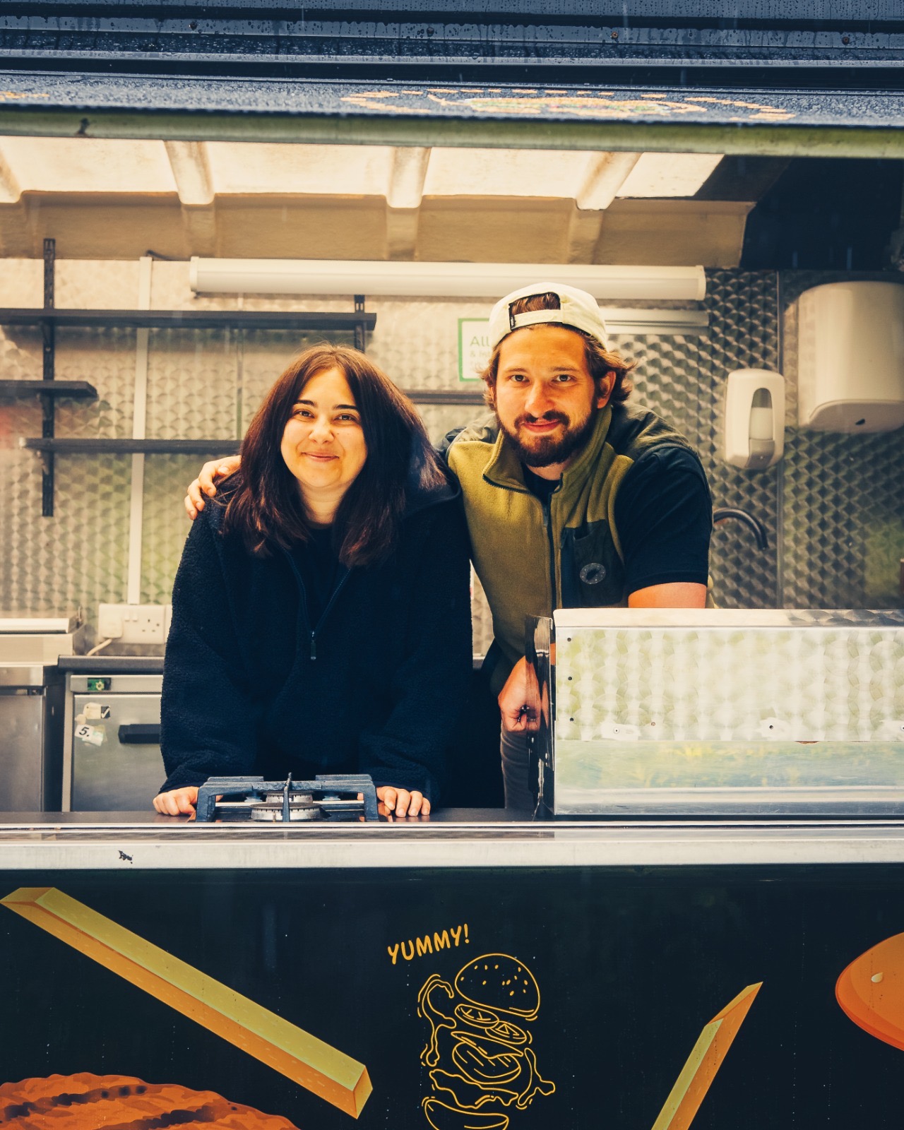 Two people together at the Reubens food-truck hatch