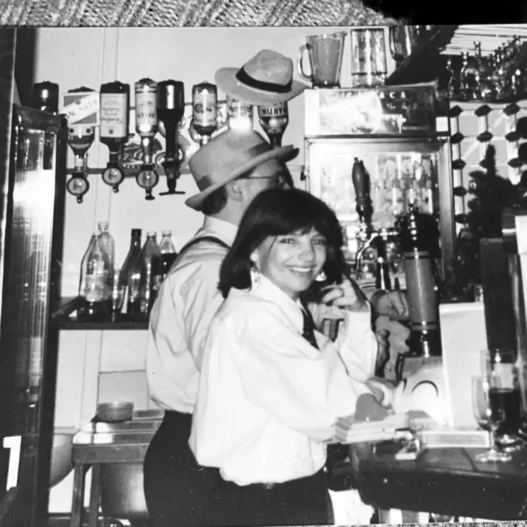 A black-and-white archive photograph of people working behind a bar